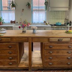 vintage wood kitchen island with brass drawer pulls and flowers on the counter
