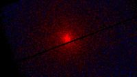 A red glowing light surrounded by black edges with cracks of black throughout the image