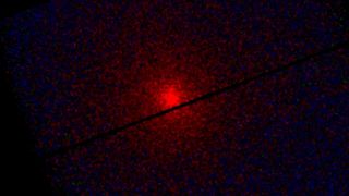 A red glowing light surrounded by black edges with cracks of black throughout the image