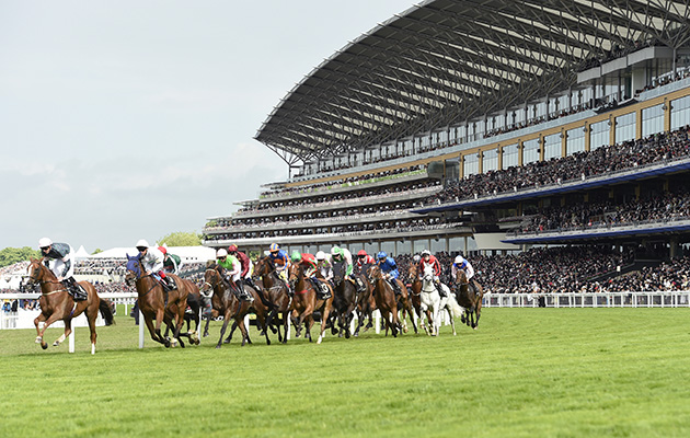 The Royal Ascot action Runners in the Gold Cup pass the impressive grandstand Ascot: library image