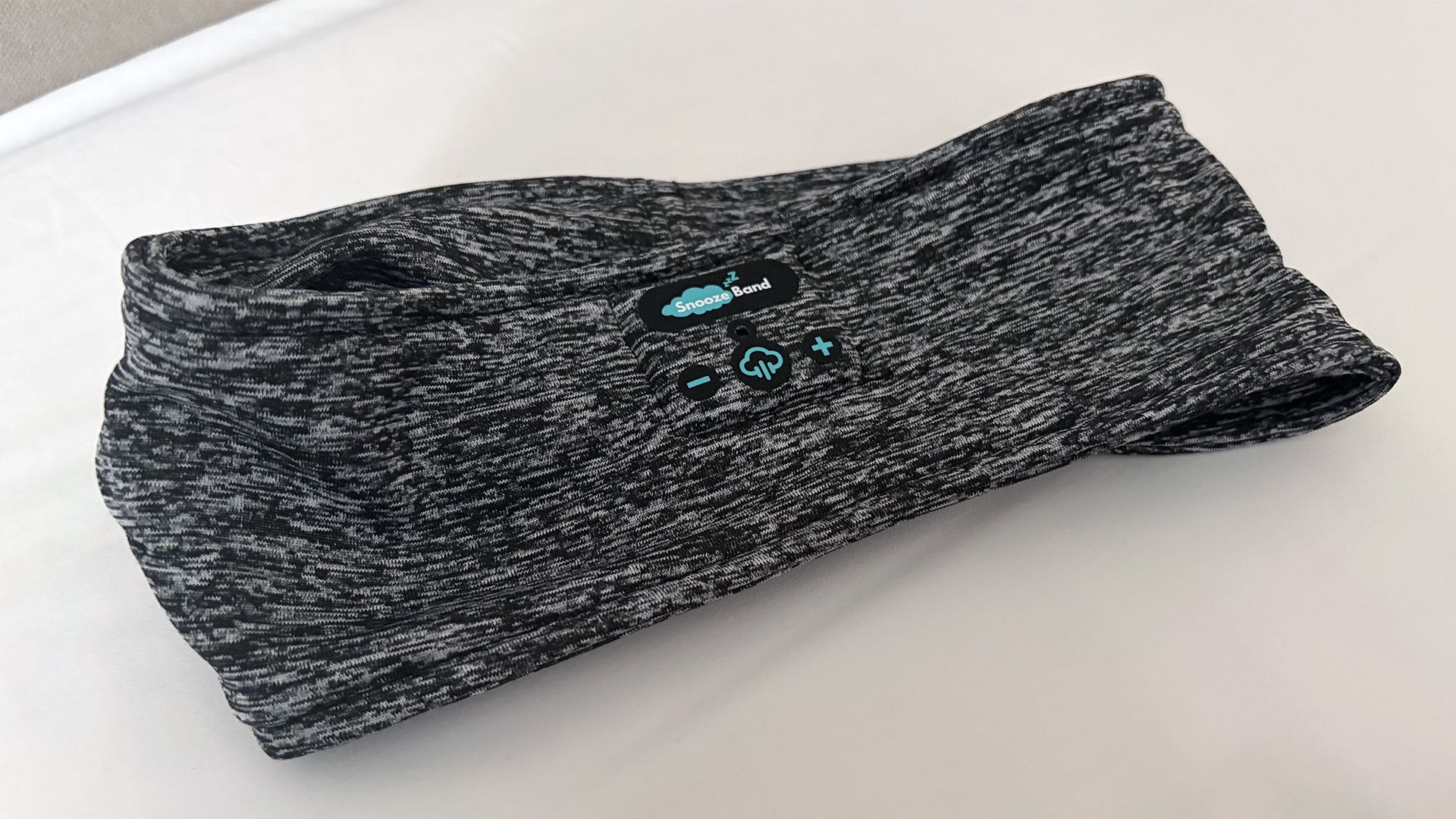 The Snoozeband Sleep headband lying flat on our reviewer's pillow