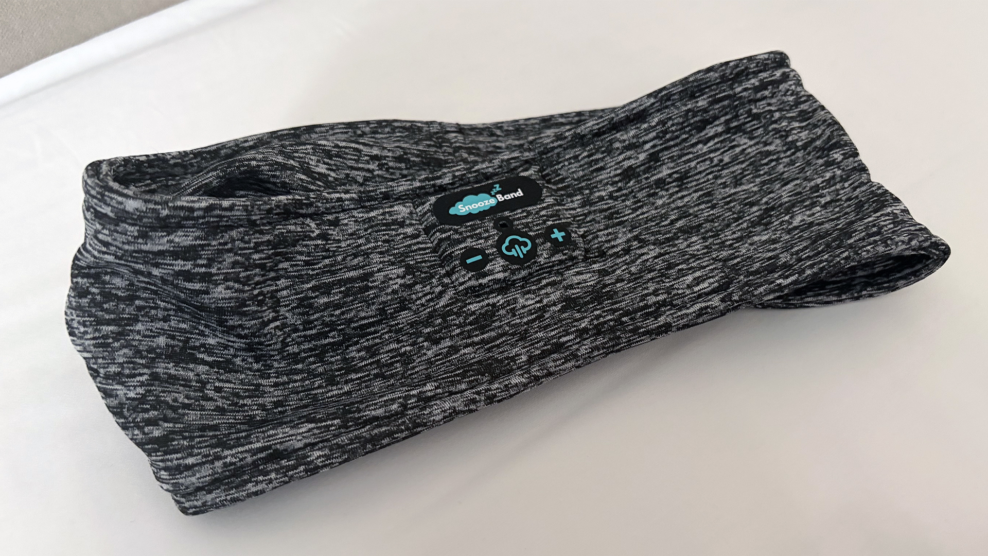 The Snoozeband Sleep headband lying flat on our reviewer's pillow