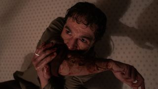 Christopher Abbott as Blake chewing on his arm in Wolf Man