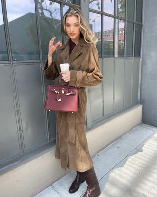 Elsa Hosk wearing a brown suede coat and burgundy Hermès bag.