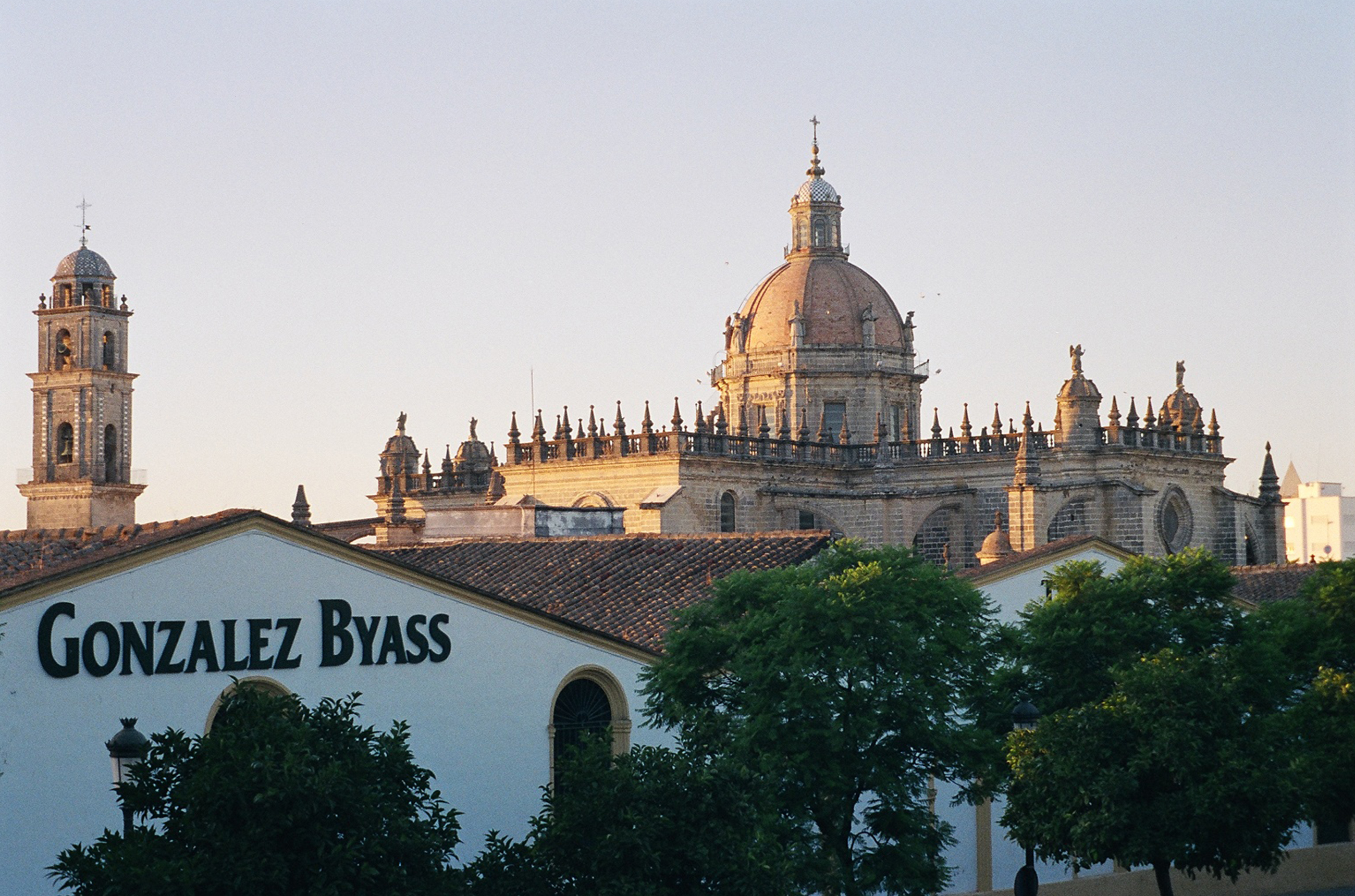 A large church with a white winery building saying 'Gonz&amp;aacute;lez Byass' in the foreground