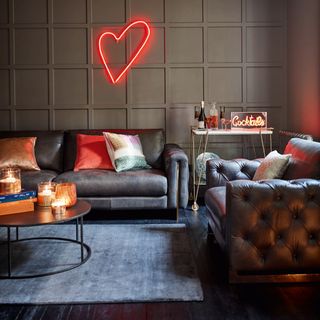 living room with grey squared designed wall grey sofa with cushions red heart shaped led