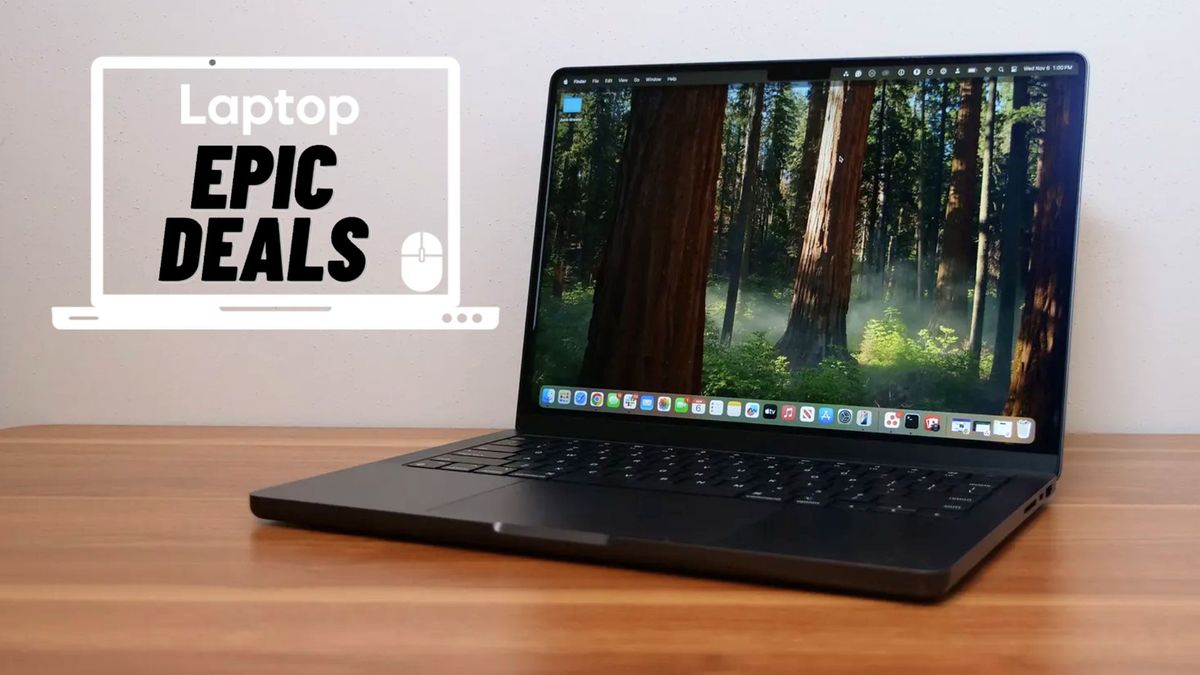 A black 14-inch MacBook Pro M4 on a wood table beside a Laptop Mag deals icon