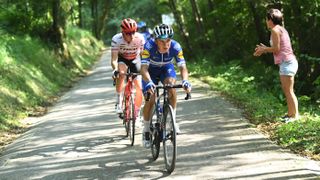 Remco Evenepoel of Belgium and Toms Skujins of Latvia ride through a forest glade during the Clásica Ciclista San Sebastián cycling race.