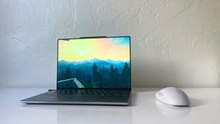 The Lenovo ThinkBook 13x G4 running Firewatch on a white table beside a gray mouse