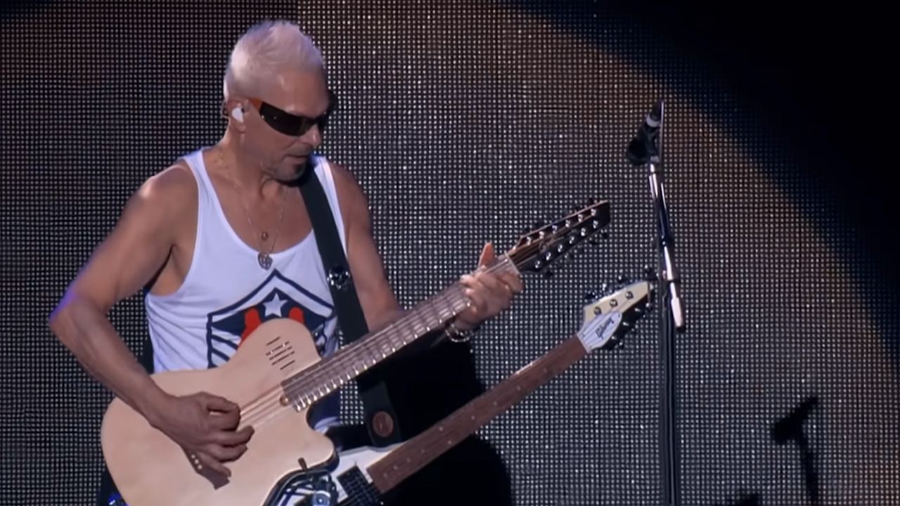 Rudolf Schenker, guitarist for The Scorpions playing a double-necked guitar on stage.
