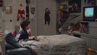 Fred Savage sitting in a bed holding a joystick and playing a baseball video game in The Princess Bride.