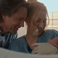 jack and mel smile while holding their newborn son in a still from virgin river season 7