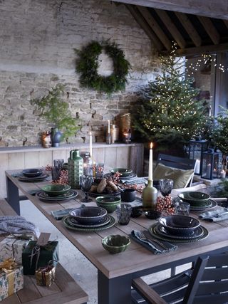 natural Christmas tree in a farmhouse, table setting, wreath, candles, tableware, presents