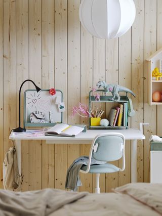 A children's desk with a whiteboard and bookshelf