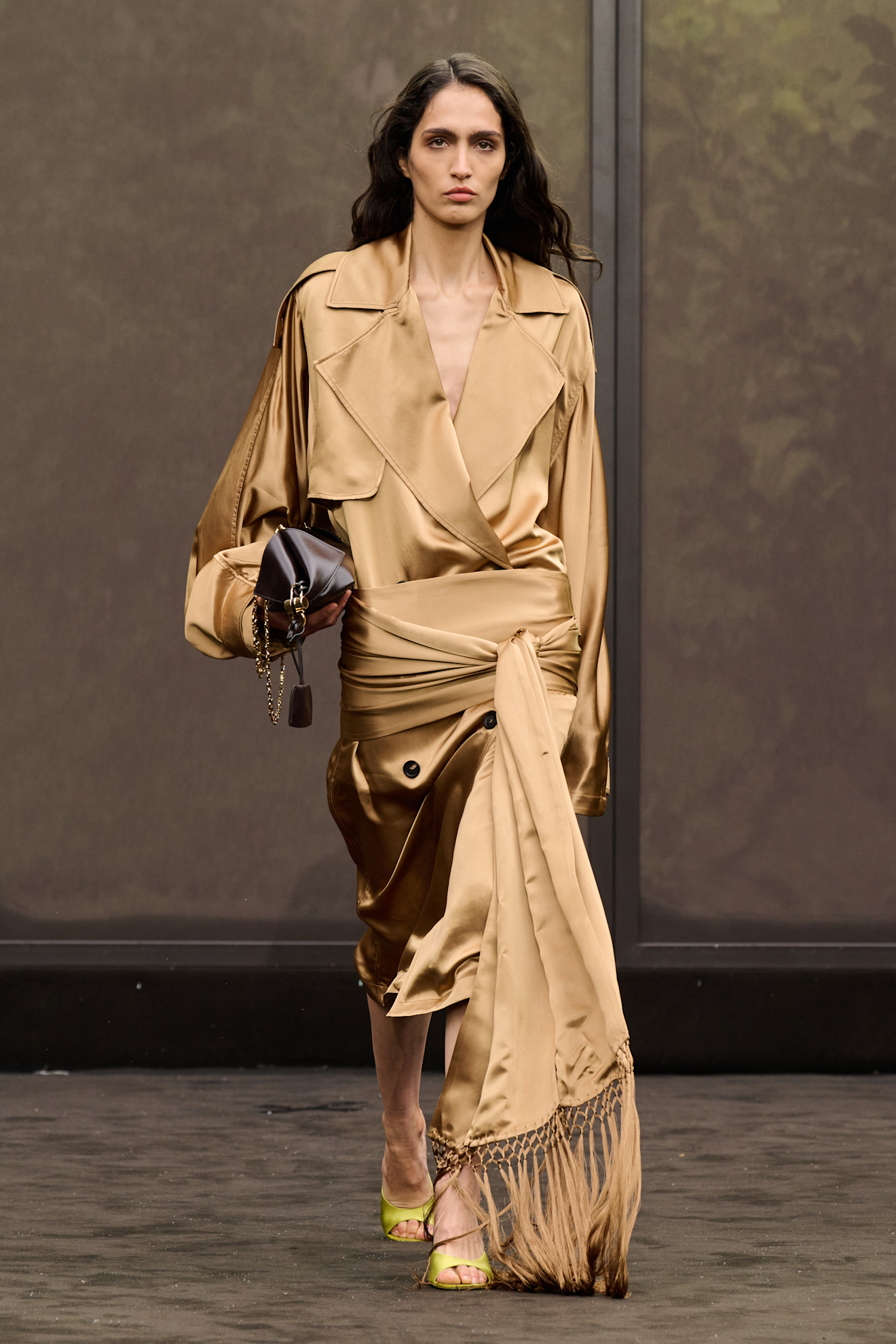 A model wearing a Ferragamo satin dress and fringed scarf.