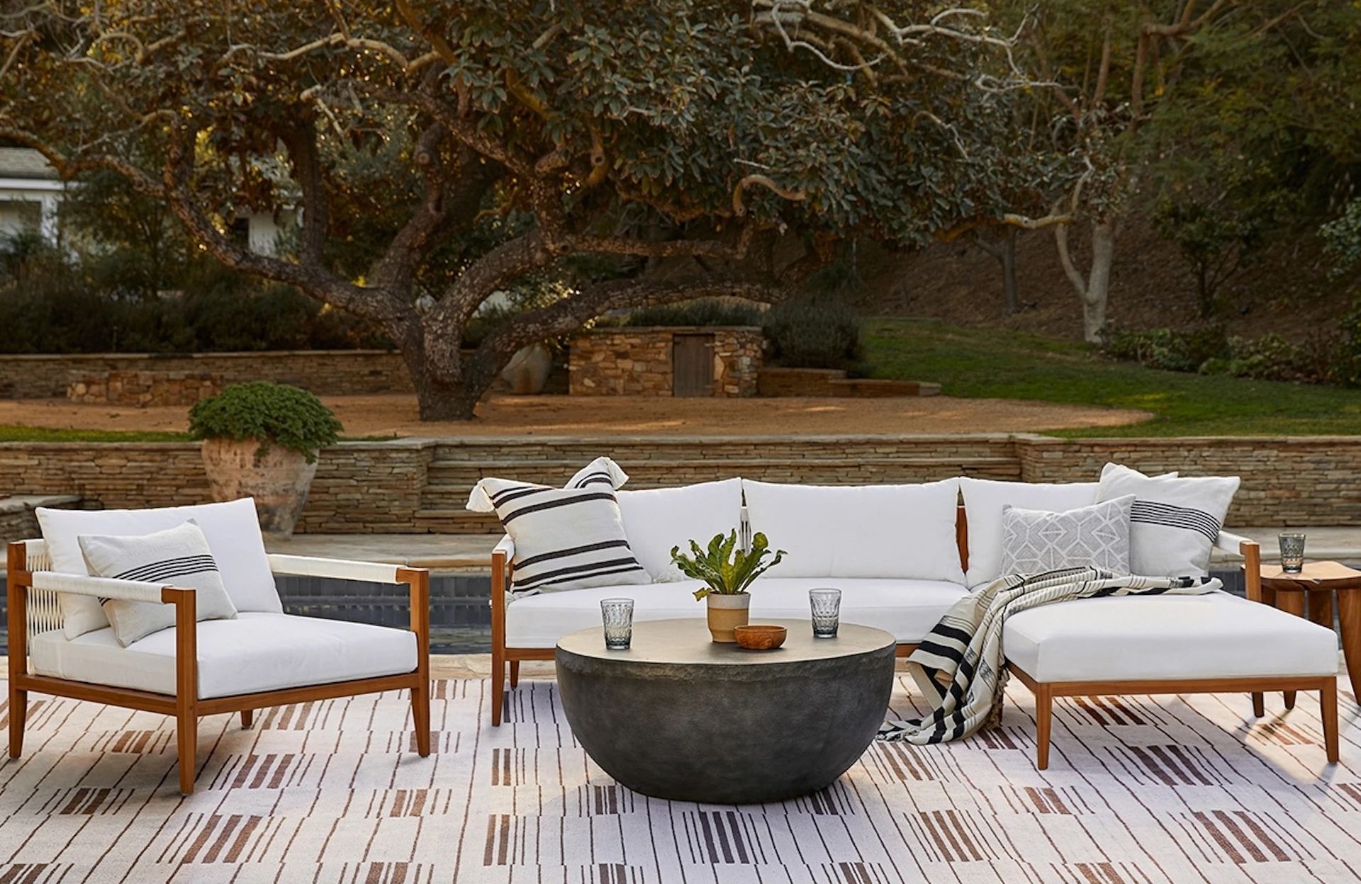 A wooden outdoor lounge set with white upholstery