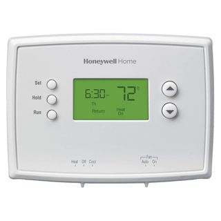 A white Honeywell Home Thermostat with green lit up screen