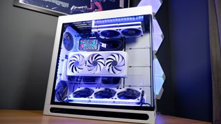 A finished white gaming PC on a table with Nanoleaf lighting panels behind it and RGB enabled.