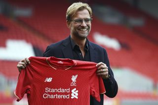 Jurgen Klopp holds a Liverpool shirt at Anfield on the day of his unveiling as manager in October 2015.