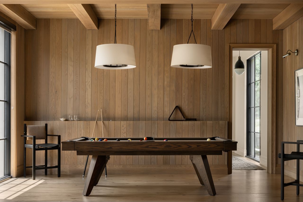 A pool table with two pendant lights overhead