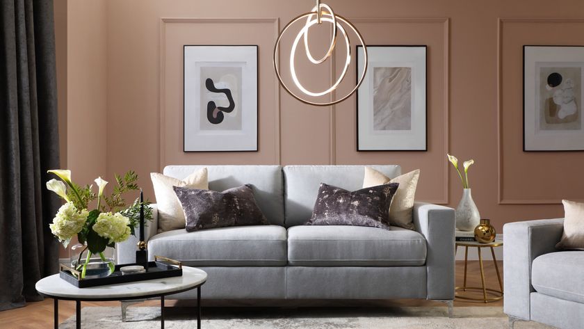 living room with soft teracotta colour panelled walls, grey sofa and pendant light