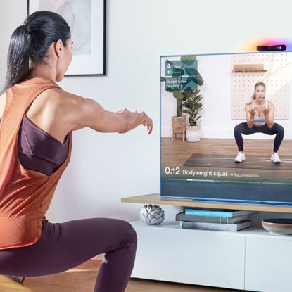 Sky Glass with Sky Live device with a woman using the workout fucntionality 