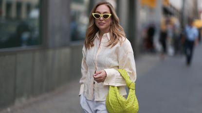 Sonia Lyson wearing linen shirt, Bottega Veneta lime yellow Jodie leather bag, Tods beige ballerinas, H&M grey joggingpants, Miu Miu beige logo underwear, & other stories linen beige flanell and Linda Farrow lime yellow cat eye shades on June 07, 2023 in Berlin, Germany.