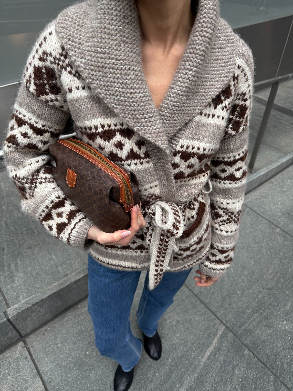 Eliza Huber wearing the Doen Hale Cardigan with jeans and a brown Celine clutch bag.