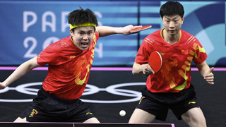 China's Wang Chuqin (L) returns the ball as China's Ma Long (R) looks on ahead of the men's Table Tennis Team final at Olympics 2024 