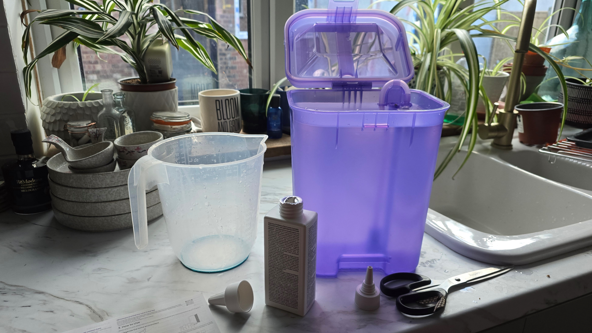 Narwal Flow water tank and detergent on kitchen counter with jug