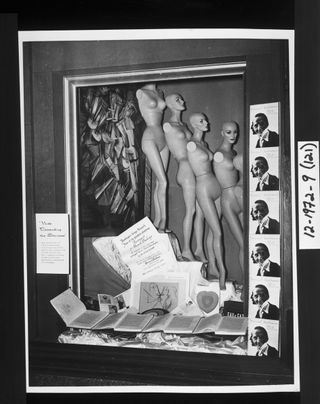 Window display with armless female mannequins and the books with open pages on display