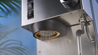 Rancilio Silvia in Stainless steel on a wooden worktop with a blue wall in the background.