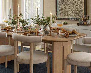Minimalist Thanksgiving decor. Modern dining room with wooden furniture, decorated table