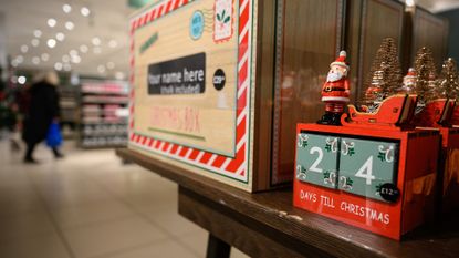 A customer browses some of the festive items in the Christmas gift and decoration section in the branch of retailer Marks and Spencer at Westfield White City