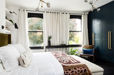 a bedroom with eyelet curtains on a rod