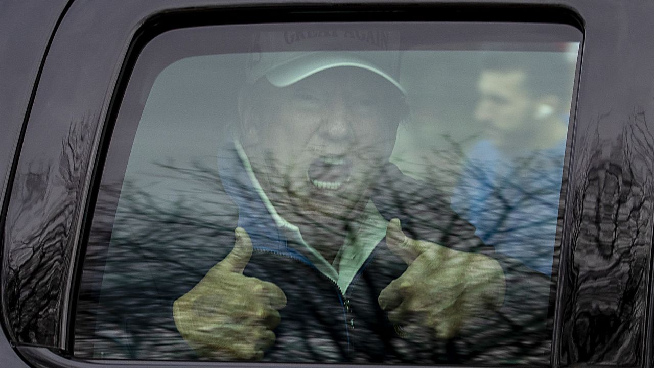 Donald Trump gives a thumbs up to supporters after golfing at Trump National Golf Club