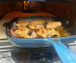 Chicken cooking in a skillet in the Ooni Karu 2 Pro