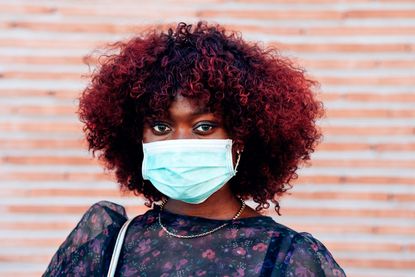 Face mask exemptions: Close Up Portrait Of Young Black Woman Wearing Face Medical Mask To Prevent Coronavirus Infection