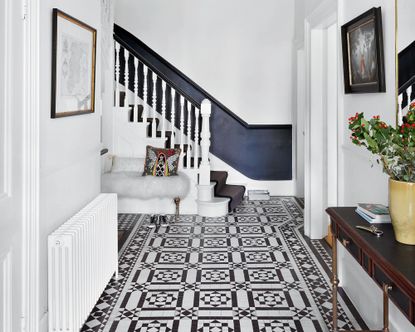White painted hallway with blue and white mosaic tiles, painted stairway in blue and white