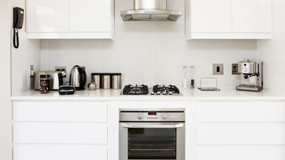 A modern white kitchen with a selection of stainless steel appliances