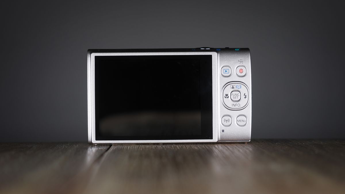 Canon Ixus 285 HS A on a wooden surface against a dark background