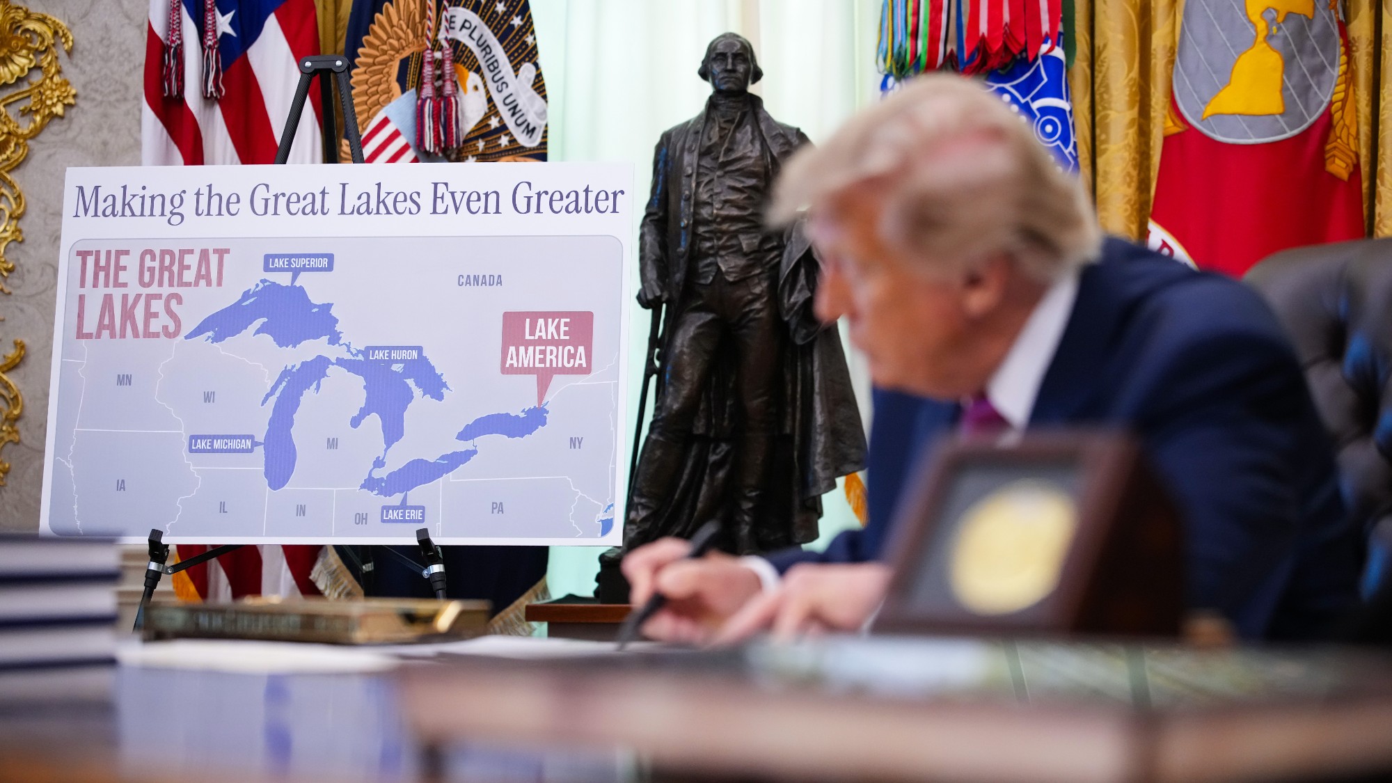 A map labelling Lake Ontario as "Lake America" is displayed as Donald Trump signs an executive order in the Oval Office