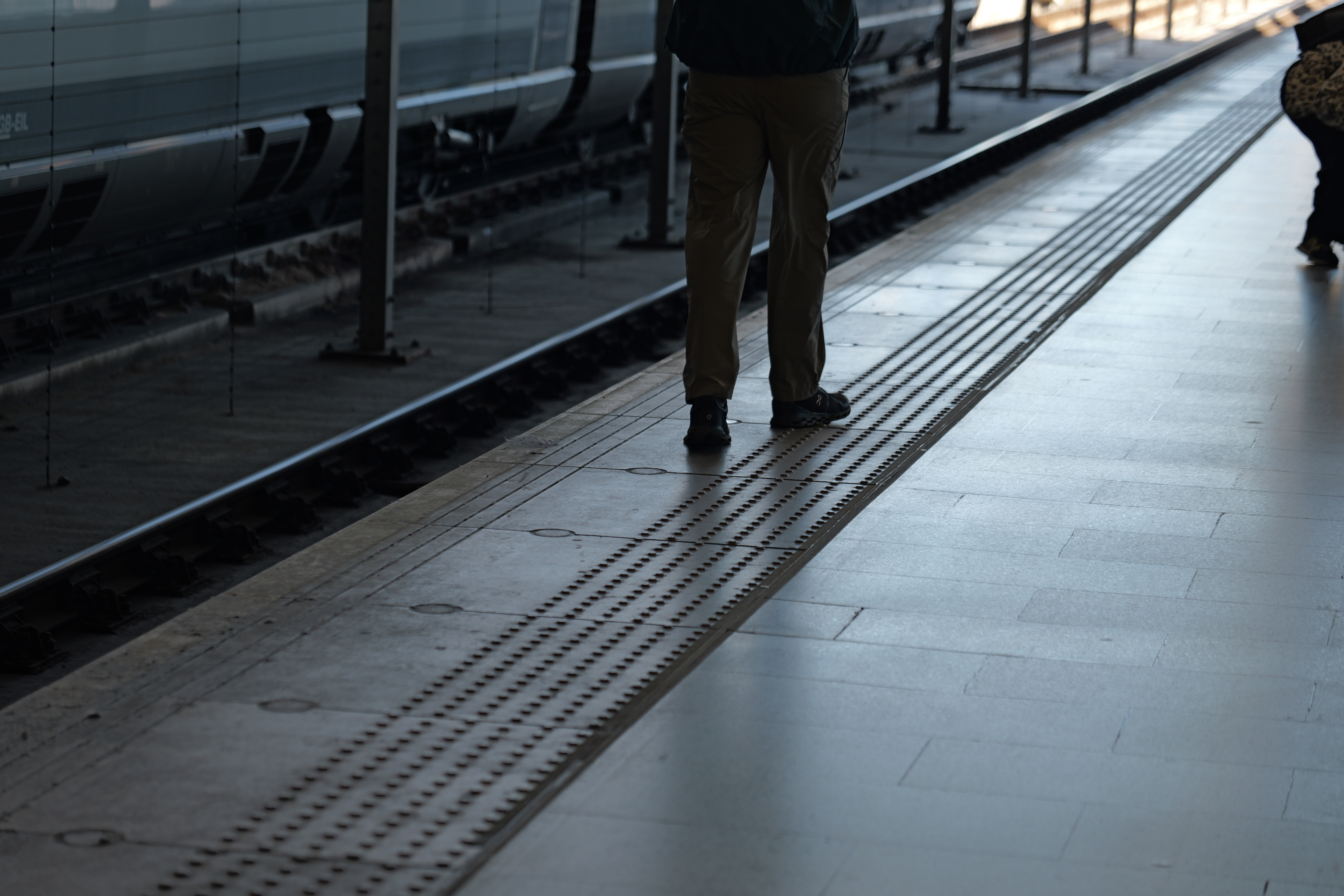 Man walking along the edge of a train platform