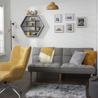 The range sofa bed in grey in a living room with white walls