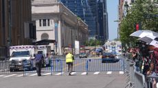 Security staff and emergency services man a roadblock in Midtown Manhattan, while press photographers look on