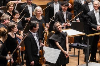 Anna Thorvaldsdottir stands on stage with the New York Philharmonic orchestra at the premiere performance of her musical composition "Metacosmos," a symphonic poem inspired by black holes.