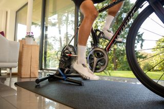 Male cyclist riding indoors on a Wahoo Kickr turbo trainer