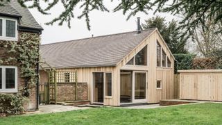 garage conversion with tiled roof, pale timber clad exterior and glazed sections on gable end