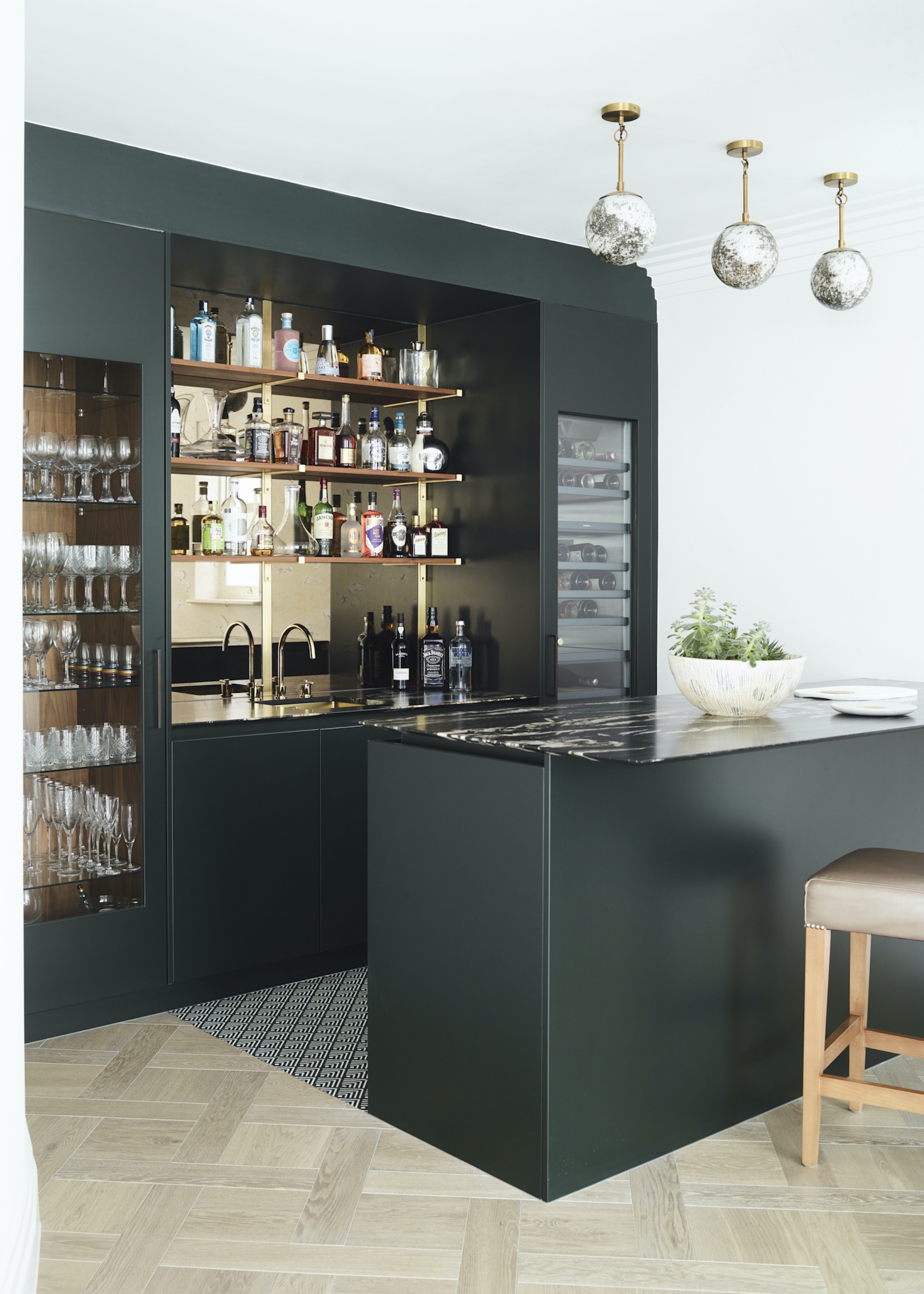 home bar with small island in front in a green color. The island also has a bar stool beside it.