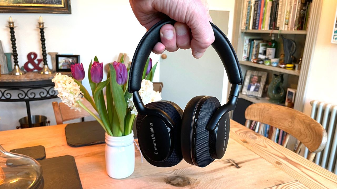 Bowers &amp; Wilkins Px7 S2e held in the air above a dining room table